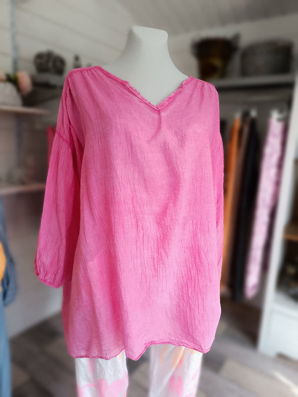 Oversized Sommerbluse aus Leinen. V-Ausschnitt mit Häelspitze. 3/4 lange Ärmel mit elastischem Bund. Leinenbluse in der trendy Farbe Pink.