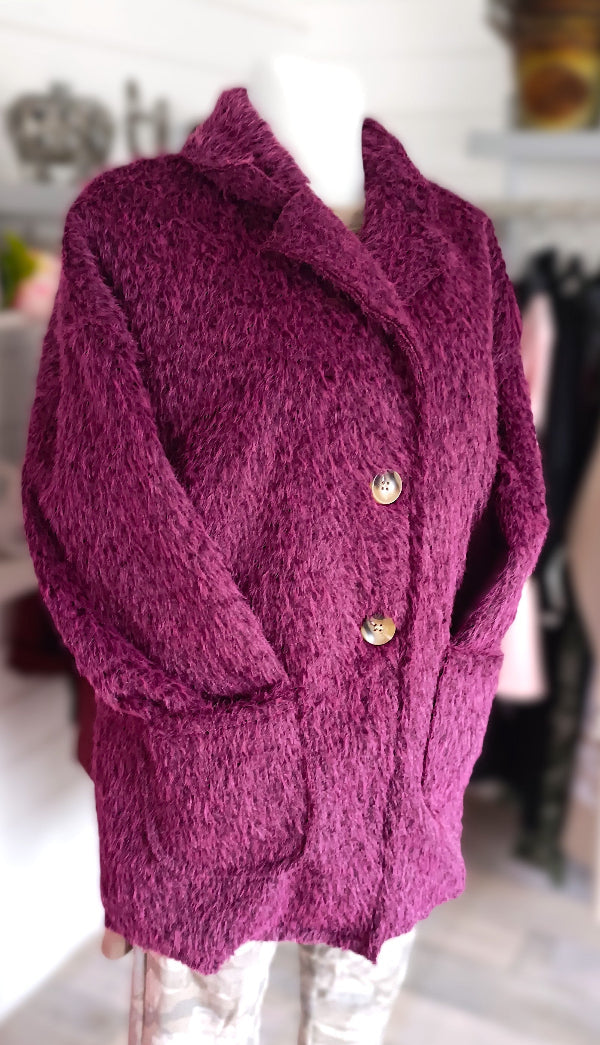 Teddy Blazer in Farbe Beere. Reverskragen, 2 Knöpfe und 2 aufgesetzte Taschen. 60% Polyester, 40% Elasthan. Armlänge ca. 47 cm, Länge ab Schulternaht ca. 74 cm, AA 60 cm. Passend bis Größe 44.